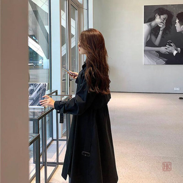 Vêtement féminin noir, trench long pour une allure sophistiquée
